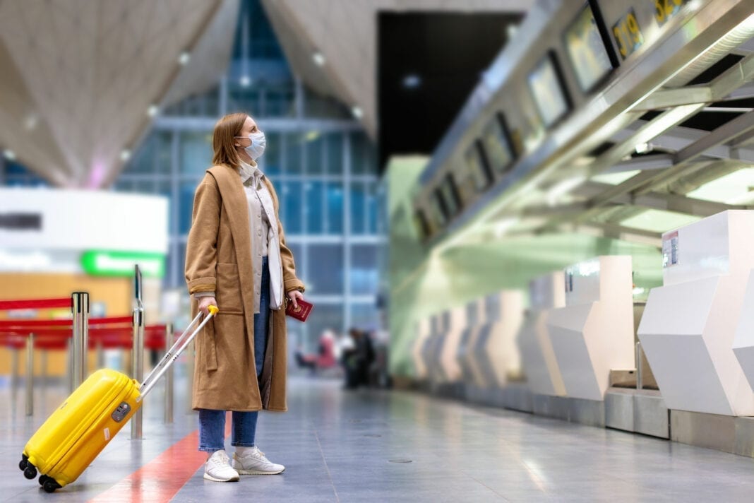 Frau mit Gepäck steht an fast leeren Check-in-Schaltern im Flughafenterminal aufgrund von Reisebeschränkungen wegen der Coronavirus-Pandemie Foto: © DimaBerlin - stock.adobe.com